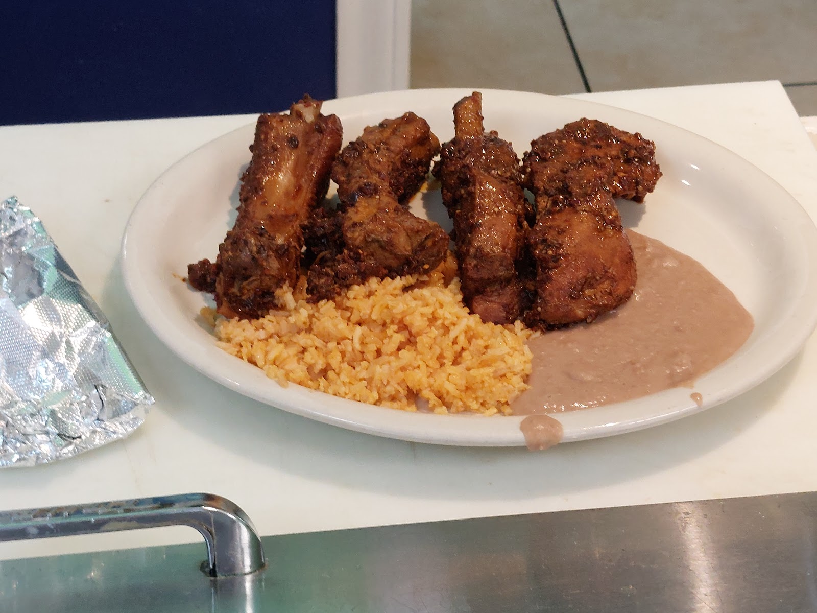 Grilled costillas rib plate with Mexican rice and refried beans